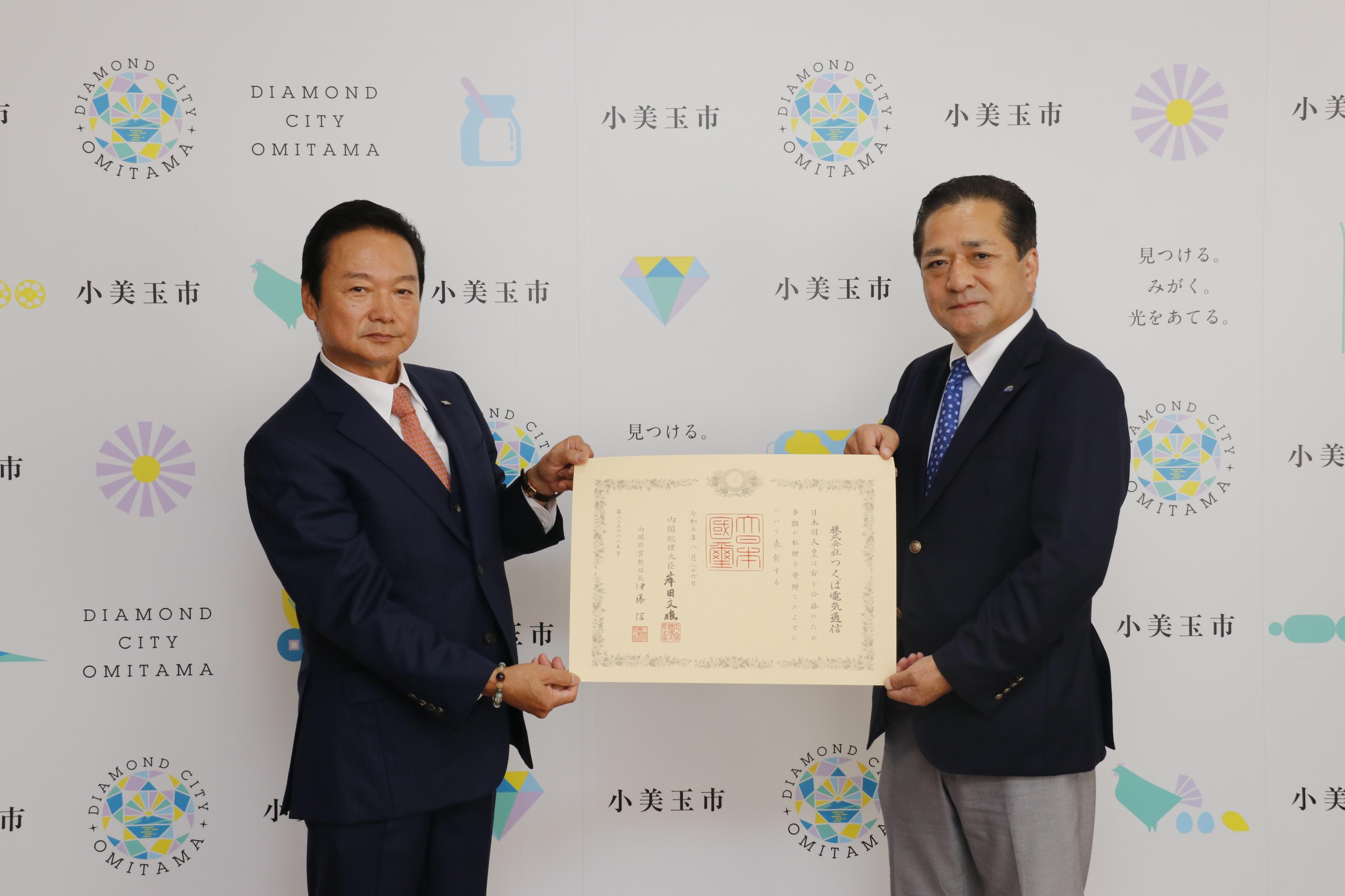 表彰状を持つ市長